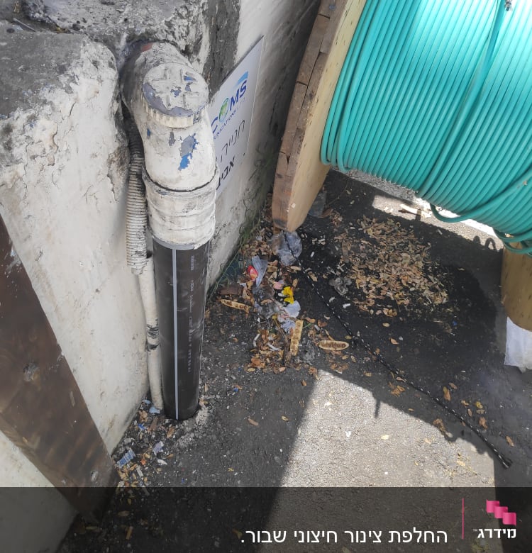צינור פלסטיק לבן ליד גליל כבלים ירוק